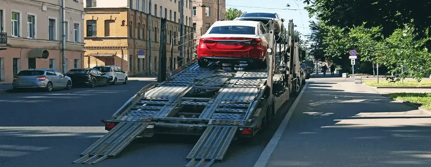 Car being loaded onto flatbed truck for transportation.
