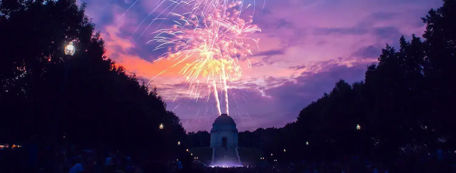 Fireworks light up the night sky in Ohio with a crowd of people watching.